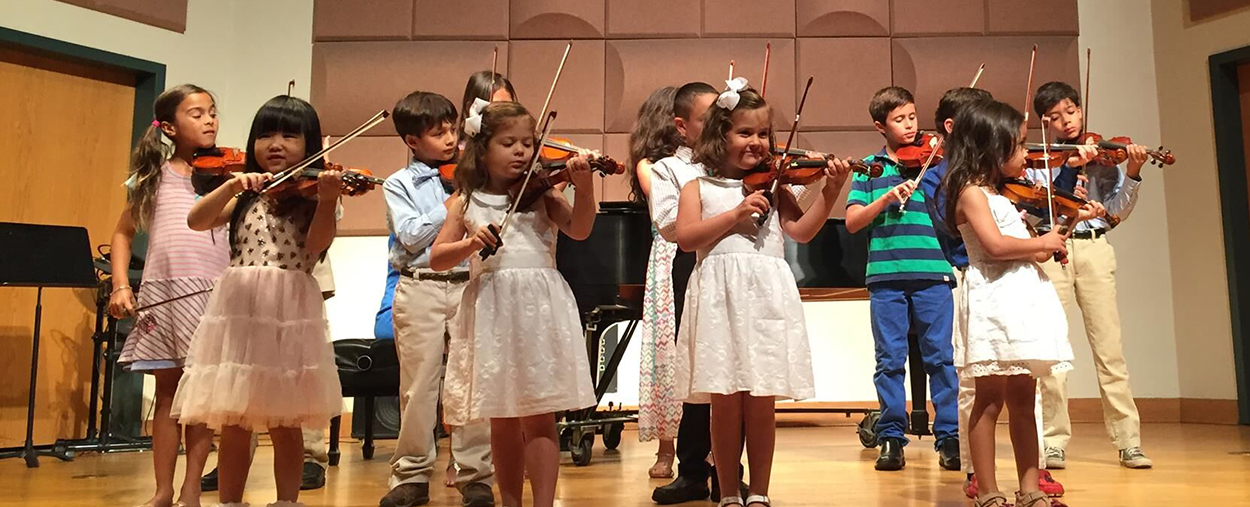 Children performing with violins at the Frost Preparatory Program
